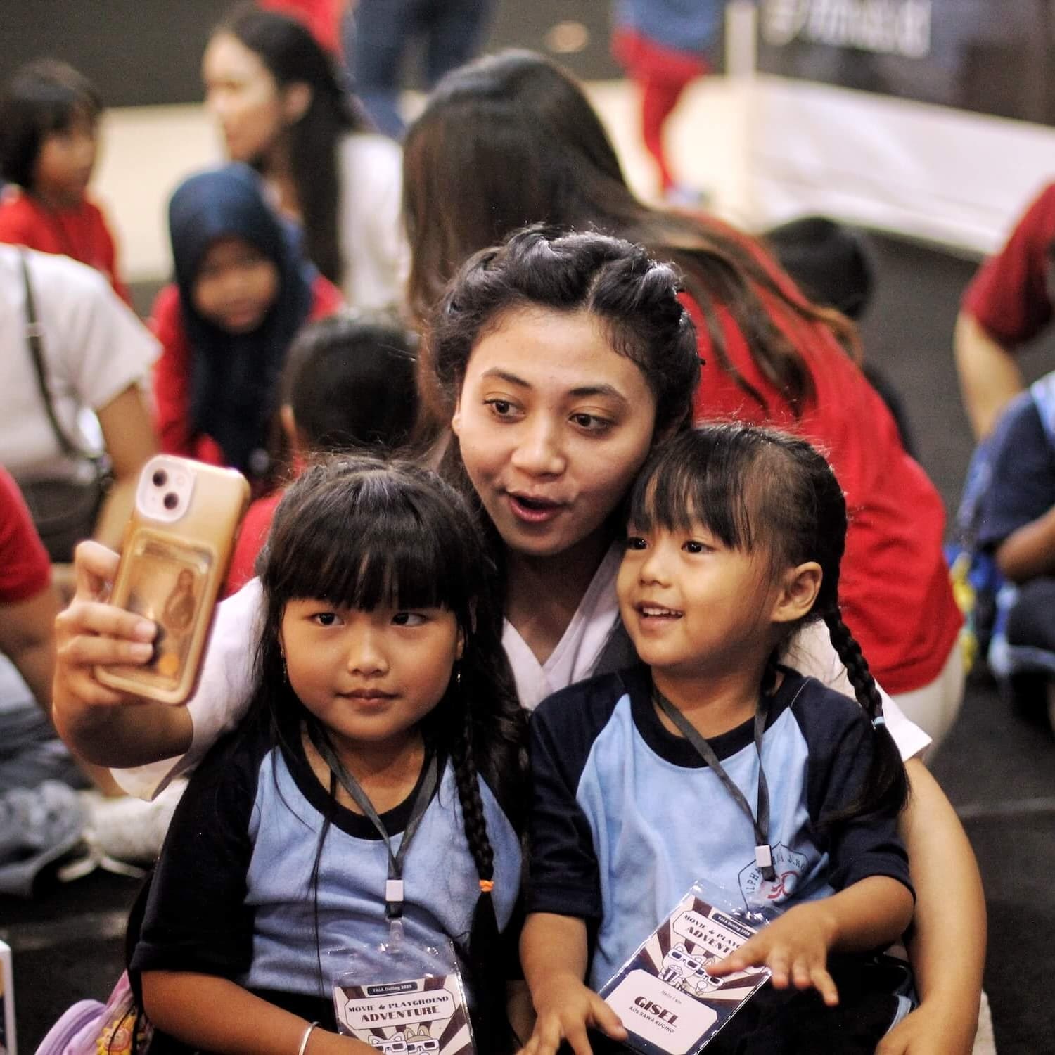 Volunteer taking a selfie with two students